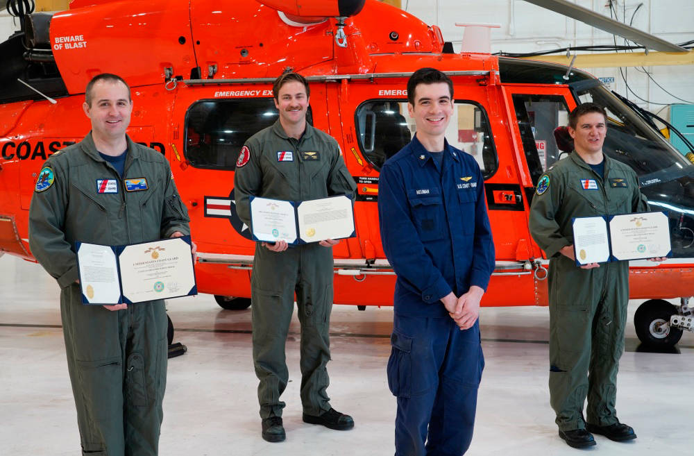 Petty Officer 3rd Class Alexander Neuman, an avionics electrical technician, presents medals to fellow aircrew members Cmdr. Michael Baird, Lt. Cmdr. Joshua Smith, and Petty Officer 2nd Class Chad Morris, at a ceremony held at Coast Guard Sector North Bend, Oregon, April 30, 2020. Baird, Smith, and Morris saved Neuman’s life in October 2019 by giving him CPR. (U.S. Coast Guard photo courtesy of Sector North Bend)