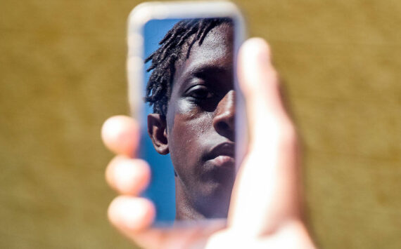 Jayden Hill, 15, an incoming sophomore at Monroe High School is reflected in the screen of a cellphone on Wednesday, July 10, 2024, in Monroe, Washington. Olivia Vanni/Sound Publishing