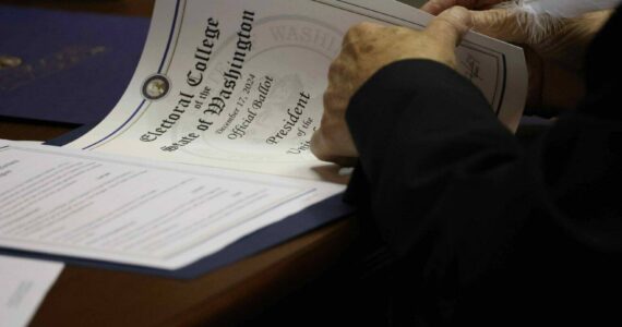 One of Washington’s 12 Democratic electors uses a feather pen to fill out the documents to cast their Electoral College vote for Kamala Harris and Tim Walz. Harris lost to Republican President-elect Donald Trump, but won a majority of Washington’s votes in the November election. (Courtesy of Washington State Archives)