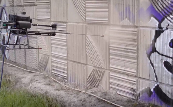 A prototype drone test sprays paint to cover up graffiti in Tacoma earlier this spring. (Courtesy of the Washington State Department of Transportation)